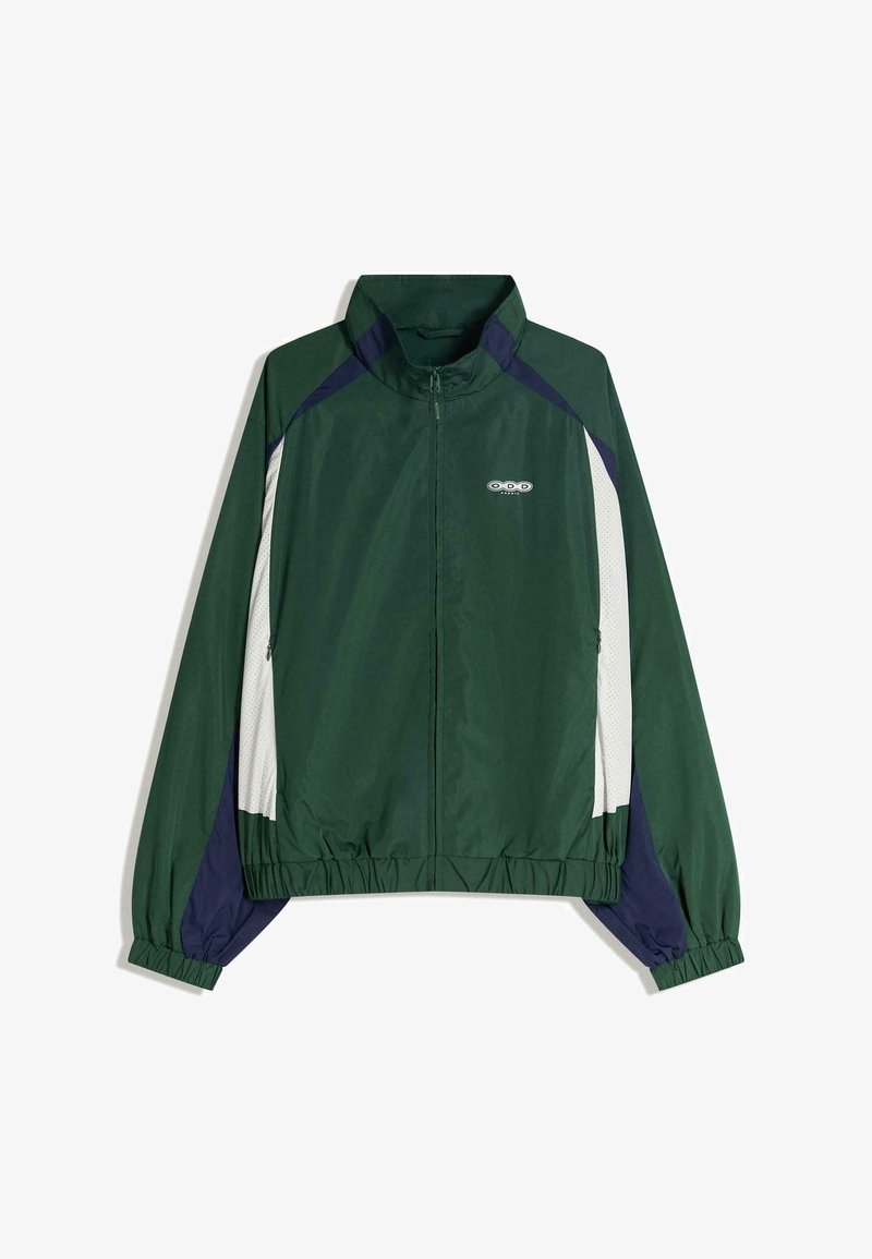Zelená bunda na zips s bielymi sieťovanými panelmi, námorníckymi detailmi, elastickými manžetami a lemom. Má logo na hrudi a golier.