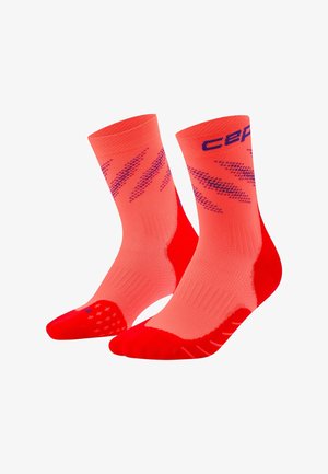 Bright orange crew socks with red toes and heels, featuring purple diagonal stripes and partial brand text near the cuff.