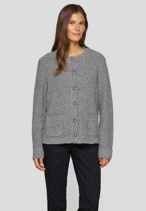 Light gray knitted cardigan with a round neckline, six buttons, and two front pockets. Soft texture and ribbed cuffs. Styled with dark pants.