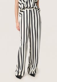 Pantaloni a gamba larga a righe bianche e nere realizzati in un tessuto leggero e liscio, dotati di una vita elastica e di una vestibilità comoda.