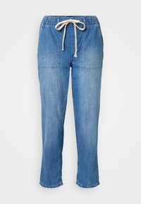 Jasnoniebieskie dżinsowe spodnie dresowe o luźnym kroju, z elastycznym pasem i sznurkiem, wyposażone w dwie przednie kieszenie oraz przeszycia.