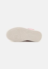 Chaussures avec une semelle en caoutchouc texturée au motif ondulé de couleur beige clair, complétées par un dessus rose. Conçues pour un usage décontracté.