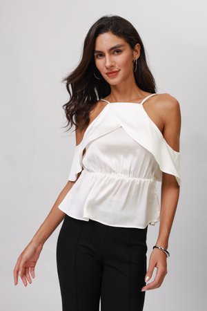 White cold-shoulder top with a layered design, elastic waistband, and lightweight fabric. Paired with black fitted pants.