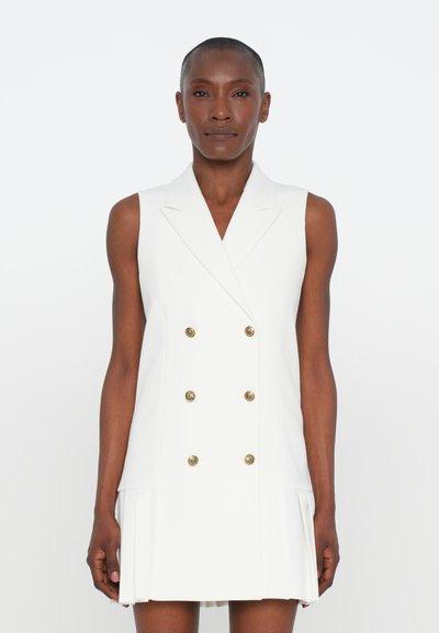 Robe sans manches blanche avec un design à double boutonnage, boutons dorés et jupe plissée. Texture lisse et coupe ajustée.