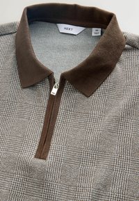 Polo en maille à carreaux marron et beige avec col marron et fermeture éclair partielle, taille moyenne, fabriqué en Turquie.