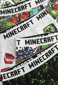 Set de lenjerie în temă Minecraft, cu benzi elastice pe care este inscripționat textul "MINECRAFT". Designurile includ modele de blocuri, grafice TNT și detalii de stropire.