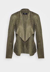 Blazer in suede sintetico verde oliva con apertura frontale drappeggiata, maniche lunghe e una texture liscia. Presenta una vestibilità comoda e un design minimalista.