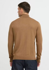 Suéter marrón de manga larga con cuello alto, hecho de una suave tela de punto. Puños y dobladillo acanalados con una silueta ajustada.