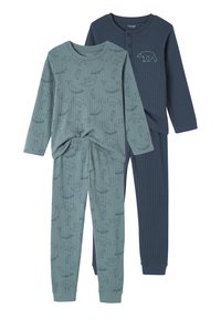 Two pairs of ribbed long-sleeve kids' pajamas, one teal with whale, penguin, and bear outlines, one navy with teal bear embroidery and buttons.