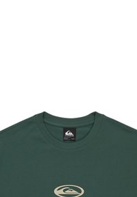 Green cotton T-shirt with a crew neckline, featuring a large white logo on the chest and a tag label at the back of the neck.