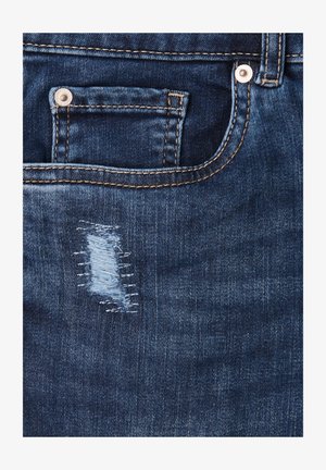 Tejido de mezclilla azul oscuro que presenta un área pequeña desgastada con hilos blancos visibles y un bolsillo para monedas asegurado por un botón de metal.