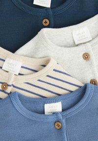 Drei Babyjacken in Marineblau, Hellblau und mit cremefarbenen Streifenmustern. Sie verfügen über einen strukturierten Stoff, runde Halsausschnitte und Holzknöpfe.