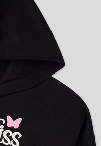 Felpa nera con un grafico di una farfalla rosa e testo bianco. Il materiale sembra morbido; il design include una forma a cappuccio classica con dettagli di cucitura.