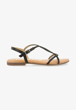 Sandalias planas de cuero negro con tiras trenzadas, hebilla ajustable en el tobillo y una plantilla beige. Diseño delgado con suela plana de goma.