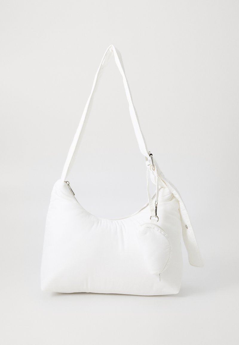 White nylon shoulder bag with a soft, rounded shape, long strap, zip closure, and a detachable small pouch attached.