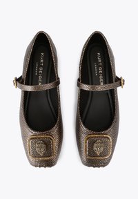 Bruine balletpumps met een textuur, een ronde neus en een enkelriempje. Voorzien van een gouden decoratief accenten op de neus.