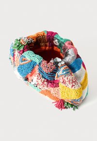 Mehrfarbige Perlenhandtasche mit aufwendigen Mustern, gemischten Textilien und Verzierungen, die verschiedene Formen und Texturen aufweist.