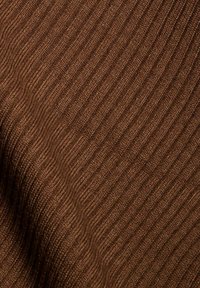 Bruine geribbelde stof met een gestructureerd oppervlak met afwisselende verticale lijnen. Zacht, gebreid materiaal met een warme tint.