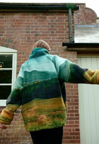 Veste en polaire avec un design de paysage dégradé dans des teintes de vert, bleu et marron. Col montant, coupe oversize, avec des poignets côtelés et un ourlet à cordon de serrage.