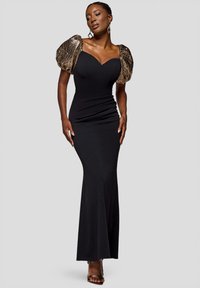 Svart figurnära klänning med hjärtformad urringning och gyllene, strukturerade puffärmar. Golvlång design med slät tyg och subtila rynkningar.