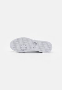Sole din cauciuc alb cu un model de grilaj texturat. Previne un accent circular și un detaliu de branding. Design curat, minimalist.