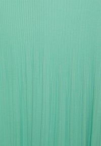 Tissu en chiffon vert menthe avec des plis verticaux ; texture légère, finition lisse et apparence fluide. Aucun accessoire ou détail notable.