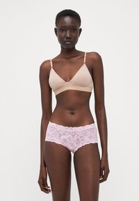 Beige triangle bralette with adjustable straps paired with pink floral lace hipster briefs featuring a scalloped hem and soft texture.
