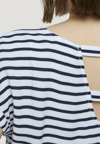 Námořnické a bílé pruhované tričko s krátkými rukávy, s vykrojením na zádech a tenkými ramínky zvýrazňujícími výstřih.