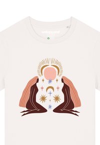 Cremfarbendes T-Shirt mit cartoonhaften Illustrationen von zwei Figuren mit langen Haaren, umgeben von Sternen und einem Sonnenmotiv in sanften Farben.