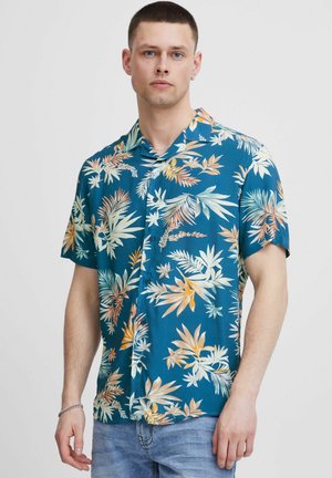 Short-sleeve, button-up shirt in teal fabric with vibrant floral print in cream, orange, and green. Features a relaxed collar and casual fit.