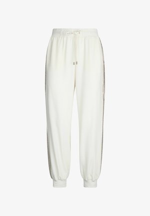 Pantaloni della tuta bianchi con vita elastica e coulisse. Presentano accenti laterali con un bordo decorato e polsini alla caviglia. Texture morbida.