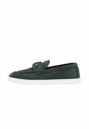 Mocassin en cuir vert foncé avec une semelle en caoutchouc blanche et une bride décorative sur le dessus, vu de profil.