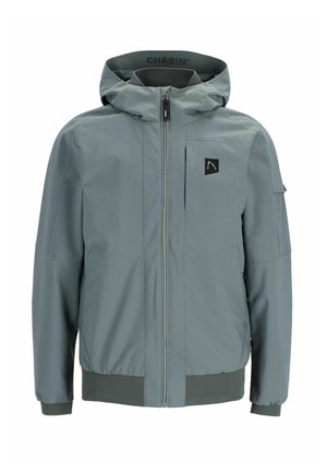 Chubasquero gris con cremallera frontal, capucha ajustable con cordón, puños elásticos y un bolsillo en el lado izquierdo del pecho. Presenta un parche con el logotipo.