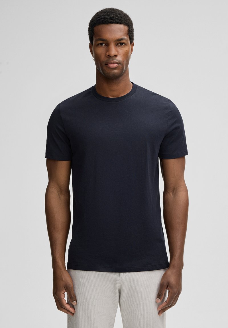 T-shirt en coton bleu marine à manches courtes, col rond et texture lisse. Présente une coupe classique sans motifs ni accents.