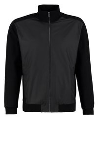 Veste noire à fermeture éclair avec col montant, poignets et ourlet côtelés, présentant un devant lisse et des manches en tissu doux.