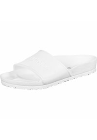 Białe klapki wykonane z gumy, z teksturowanym paskiem z wytłoczonym logo oraz żłobioną podeszwą dla lepszego chwytu.