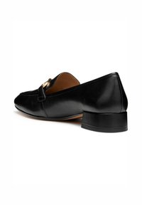 Zwarte leren loafers met een lage blokhak, featuring een ronde neus en een goudkleurige gesp op de wreef. Gladde textuur overal.
