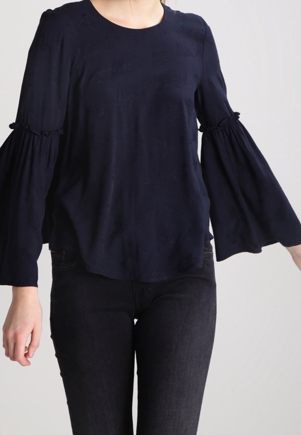 Blusa blu navy in tessuto leggero, con maniche a campana arricciate e scollatura rotonda con motivi di texture sottili.