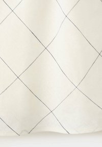 Tissu blanc avec une texture douce subtile comportant de fines lignes noires formant un grand motif de quadrillage en losanges.