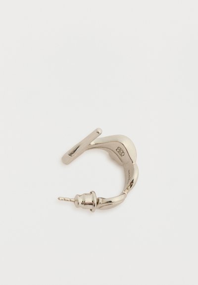 Μικρό ασημί στριφογυριστό σκουλαρίκι κρίκος με καρφί και πεταλούδα στην πίσω πλευρά σε λευκό φόντο.