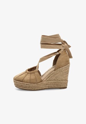 Espadrille de cuña de ante color beige con puntera cerrada, suela trenzada de yute y lazos que se atan alrededor del tobillo.