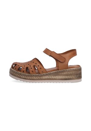 Brown leather sandal with cut-outs and an ankle strap, featuring a woven platform sole for added height and comfort.