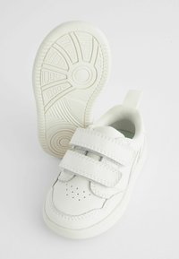 Witte leren sneakers met twee klittenbandsluitingen, geperforeerde details, een gewatteerde kraag en een gestructureerde rubberen zool.