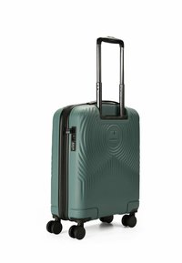 Tealfarbene Hard-Shell-Reisetasche mit strukturiertem Wellenmuster, schwarzem Reißverschluss und ausziehbarem Griff. Vier Rollen für einfache Mobilität. Kompaktes Design.