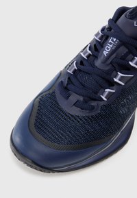 Jūrinio stiliaus sportiniai batai su tinkleliu viršuje, apvaliu pirštu ir sustiprintu guminiai padu. Su kontrastu atspalvių raišteliais ir ženklinimu ant liežuvėlio.