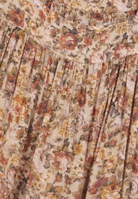Falda floral de tejido beige con un diseño plisado. Flores en tonos de rosa, naranja y verde, con una superficie texturada y una cintura fruncida.