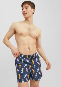Pantaloni da bagno navy con un motivo di caramelle in colori pastello. Vita elastica con cordoncino, realizzati in materiale leggero.