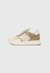 Beige en crème sneakers met een gestructureerde bovenkant die een subtiel logo patroon heeft, platte veters en een slanke witte zool met een rubberen profiel.
