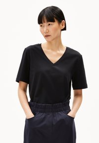 Zwarte V-hals t-shirt van zachte stof, met korte mouwen en een comfortabele pasvorm, gecombineerd met hooggewaaid marineblauwe broek met elastische tailleband.