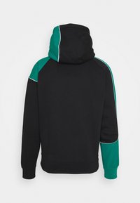 Felpa nera con un accent in teal sulla spalla e sul cappuccio, caratterizzata da una cucitura bianca a contrasto. Tessuto morbido e vestibilità standard.